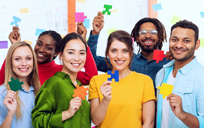 Gruppe internationaler Menschen halten bunte Puzzleteile